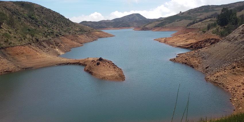 A view of Avalanche Lake in Ooty, framed by greenery and misty hills