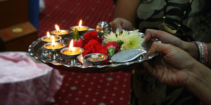 Image of a aarti thali holding for aarti decorated with flowers and diya for blessings