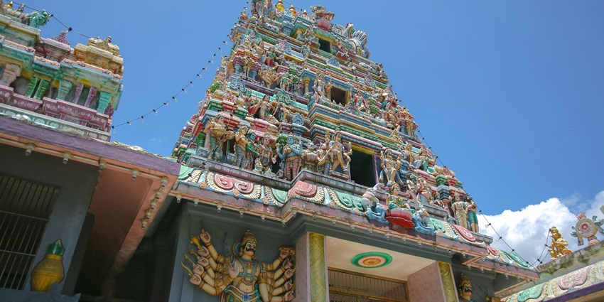 An image of a Hindu Temple tower richly embellished with numerous statues and carvings.
