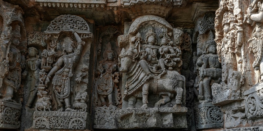A close-up view of stone carvings on Ayyappan temples in Coimbatore with carvings of deities.
