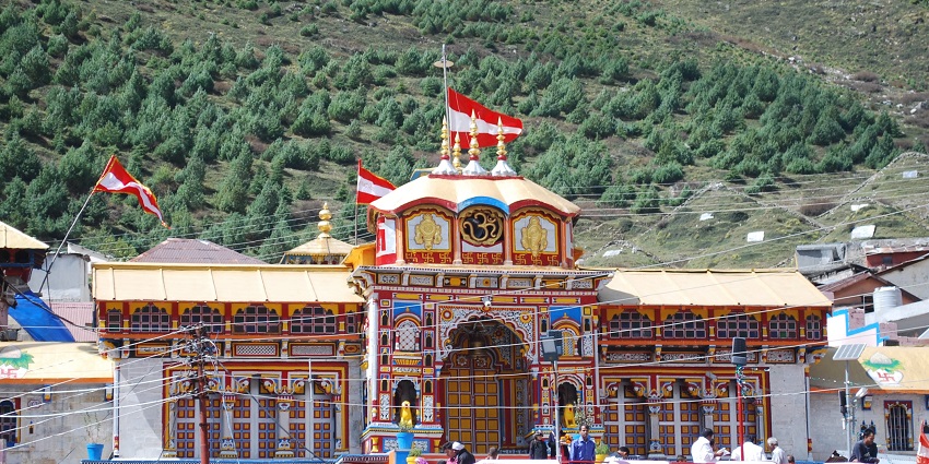 Badrinath Temple in Uttarakhand with colorful facade, set against majestic Himalayan mountains