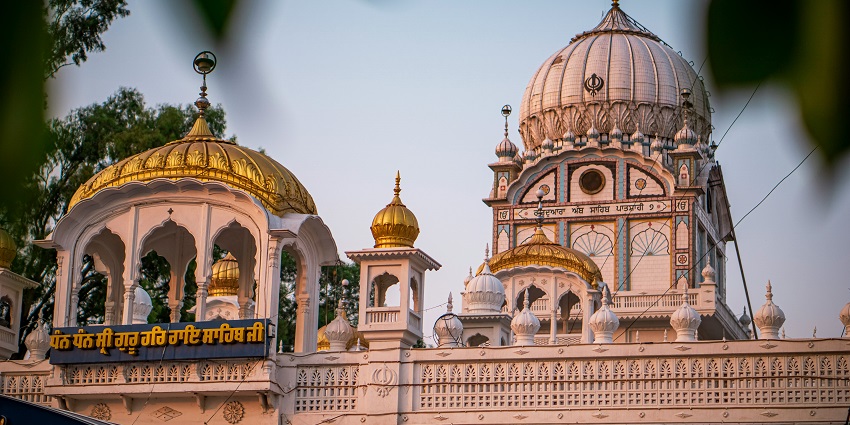 Badshahi Bagh Gurudwara with a white facade, domed architecture, and peaceful surroundings
