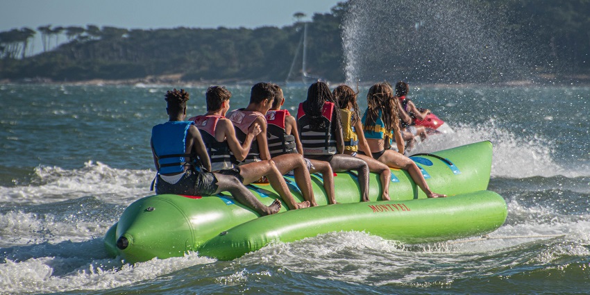 A fun image showing friends laughing together on a banana boat