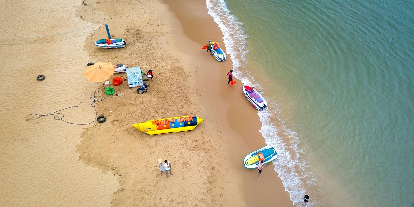 An image view of a group of friends enjoying a banana boat ride at Juhu Beach.
