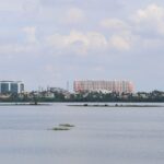 Aerial view of Chennai cityscape with tall buildings and lush greenery in the foreground.