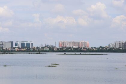 Aerial view of Chennai cityscape with tall buildings and lush greenery in the foreground.