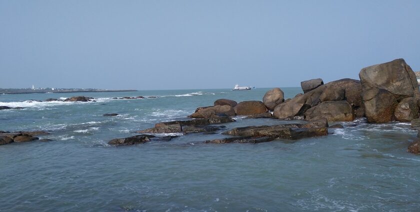 A scenic view of nature showcasing a calm beach in Nagercoil surrounded by lush greenery.