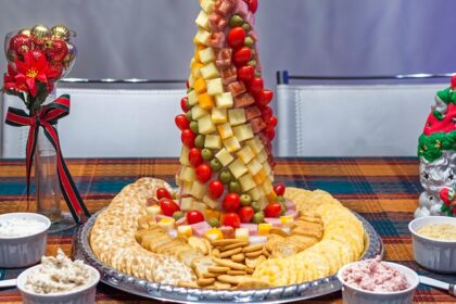 A picture of a salad dressing with numerous fruits and vegetables served in a decorative manner