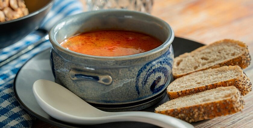 A picture of a cup of soup served alongside bread at a restaurant in Meerut