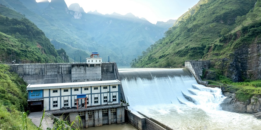 A view of a water dam surrounded by greenery, a popular tourist attraction nearby