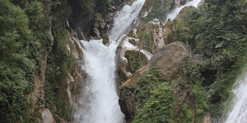 Scenic view of Bhatta falls, the silver water cascading down the rocks