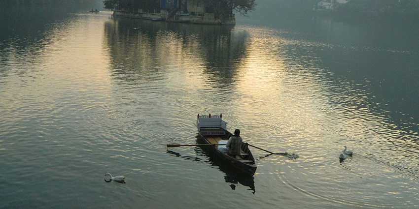Places to visit in Naukuchiatal feature a lake surrounded by hills, perfect for boating activities.