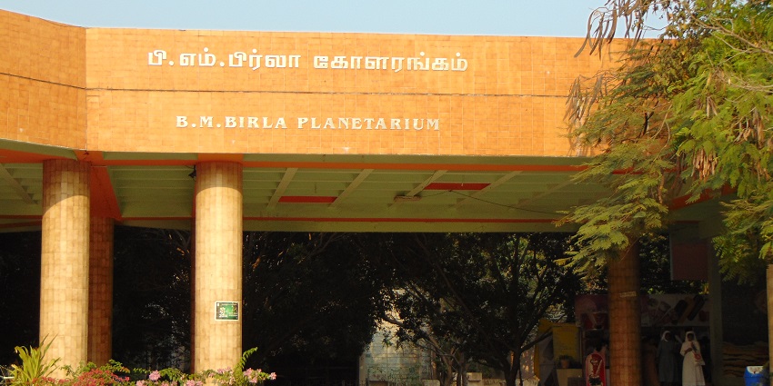 Exterior of the B.M. Birla Planetarium in Chennai, a round building with a dome and arched windows