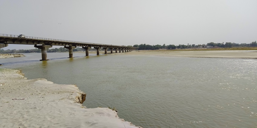 A picture of the banks of River Ganga with a huge bridge visible in the background