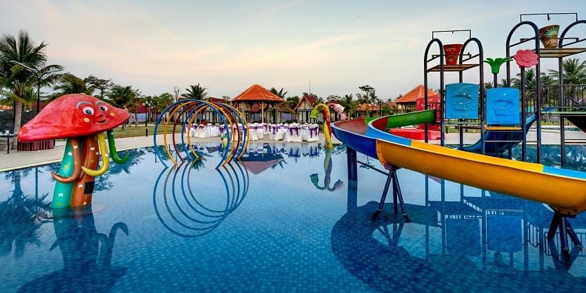 A group of people enjoying at Blue Lagoon Water Park with trees in the background.
