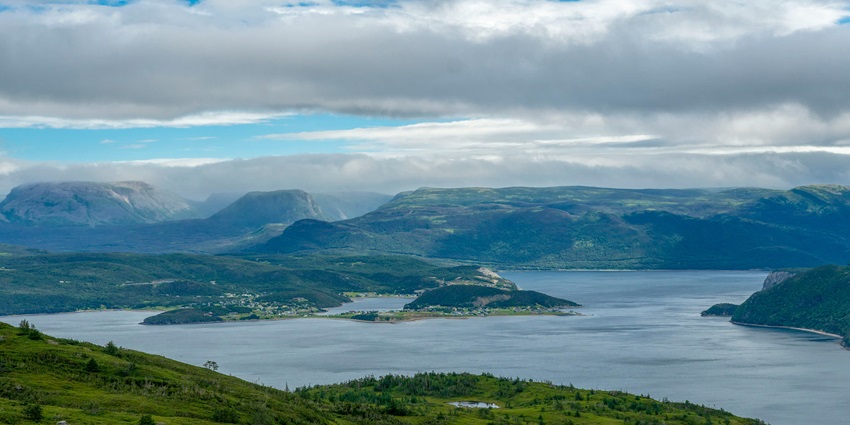 An image of green hills in Land's End along with a town on the other side in Pykara Lake