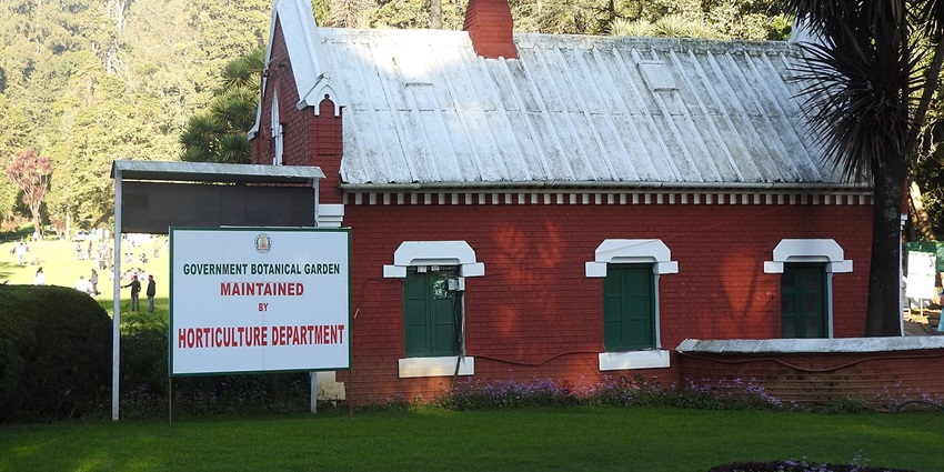 An image of the beautiful red botanical garden office in Ooty under the clear blue sky