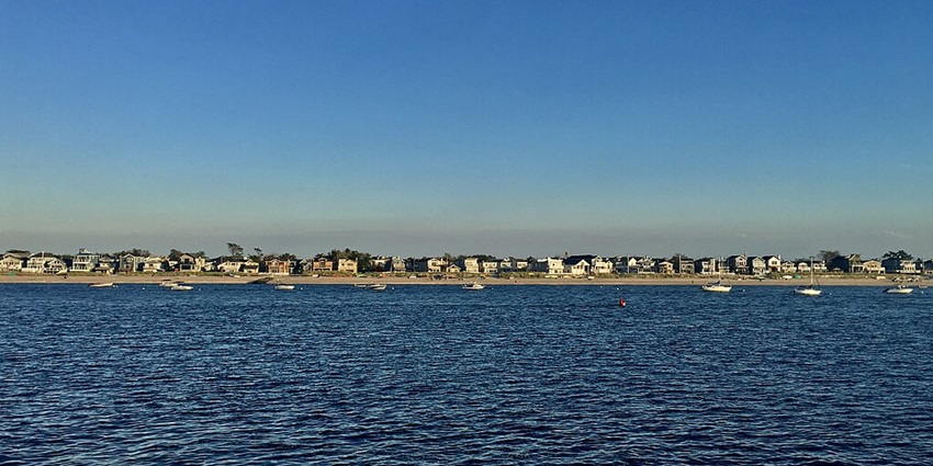 A view of Breezy Point, Queens, captured from the Rockaway Ferry under a clear sky.