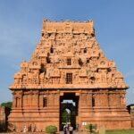 Detailed carvings on the towering Brihadisvara Temple with people on the complex.