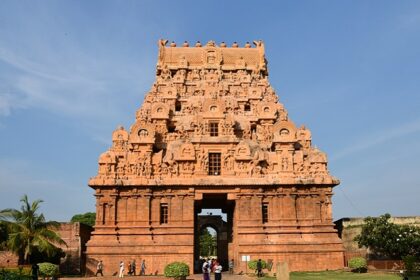 Detailed carvings on the towering Brihadisvara Temple with people on the complex.