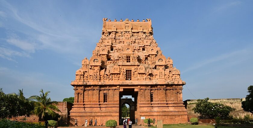 Detailed carvings on the towering Brihadisvara Temple with people on the complex.