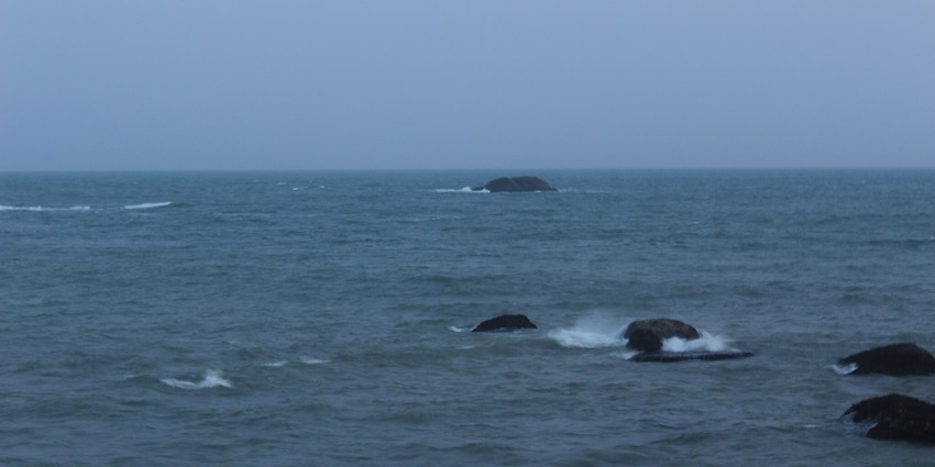View of the Indian Ocean at Cape Comorin in Kanyakumari, showing waves and coastline.
