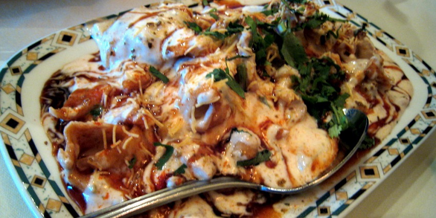 A platter of spicy, tangy chaat varieties served with chutneys and toppings.