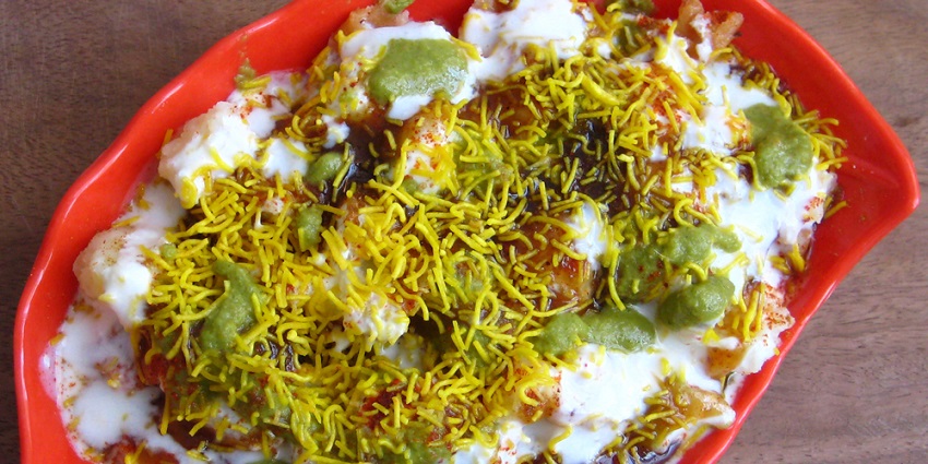 Chaat, a burst of flavours in the mouth, served on a bright red plate on a flat surface.