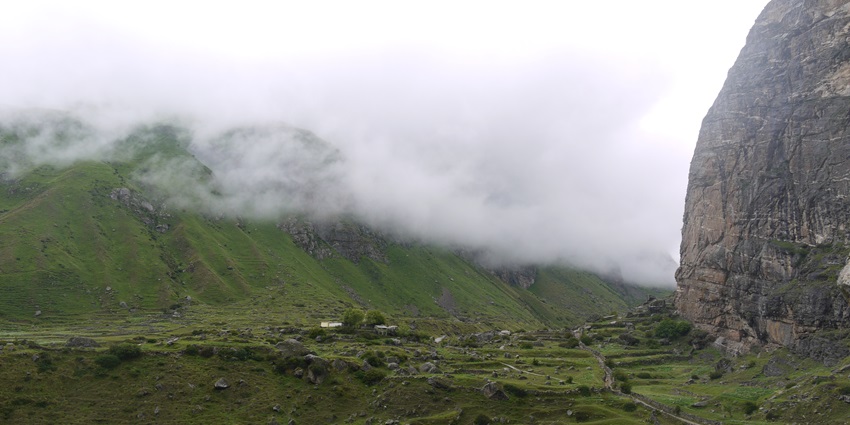 A picture of a serene valley in Chamoli district of Uttarakhand with a cover of clouds touching it