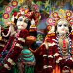 Image of idol Lord Krishna and Radha - ornate temple with a tall tower and intricate details stands against a blue sky