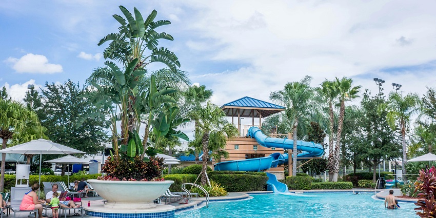 Top view of a vibrant water park with pools, slides, and people enjoying various water activities.