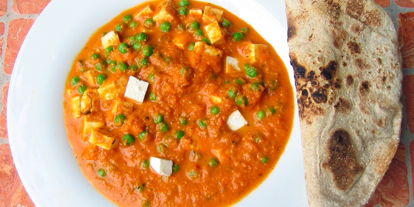 A picture of a dish made using peas and paneer served with chapati at a restaurant