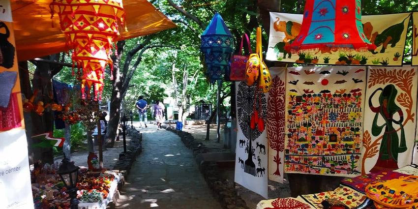 Traditional stalls in Dakshinachitra Crafts Bazaar with colourful crafts and visitors