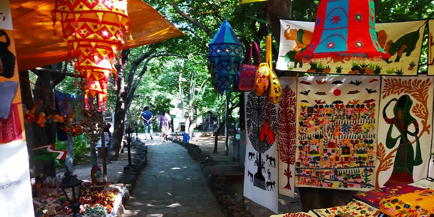 A colorful crafts market in Dakshinachitra, India, displaying pottery, fabrics, and handmade items