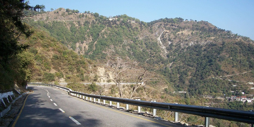 Scenic view of the winding Mussoorie-Dehradun road surrounded by lush green hills