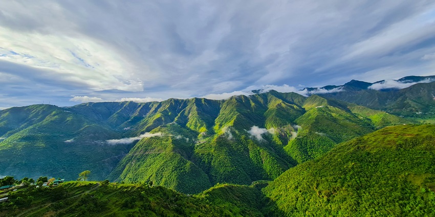 An enchanting vista of lush green vegetation and towering mountains in Uttarakhand.