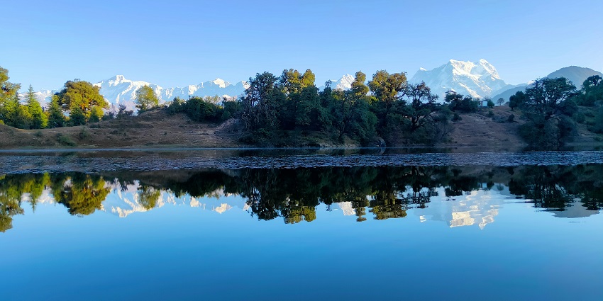 Captivating lake surrounded by majestic mountains, ideal for trekking in deoria tal.