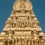 Gopuram of a Dhandeeswaram temple with carvings of deities and vibrant architectural details