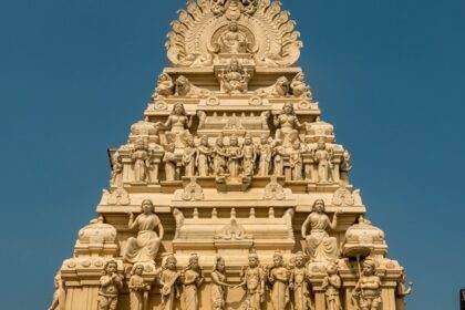 Gopuram of a Dhandeeswaram temple with carvings of deities and vibrant architectural details