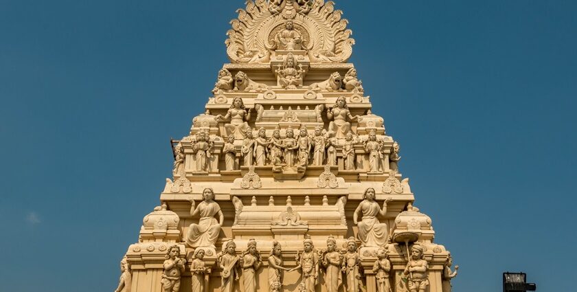 Gopuram of a Dhandeeswaram temple with carvings of deities and vibrant architectural details