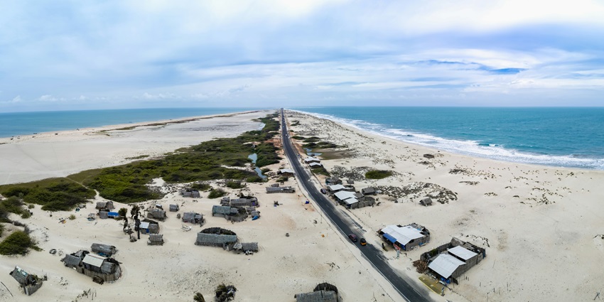 The aerial view of the ruins of Dhanushkodi alongside its deserted beach and azure waters.