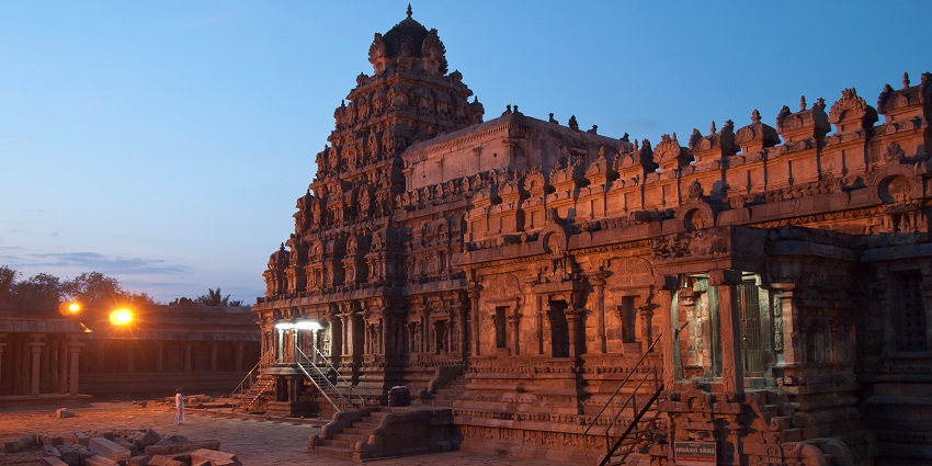 Exterior view of Dharasuram Sri Airavatesvara Temple with a man standing looking inside