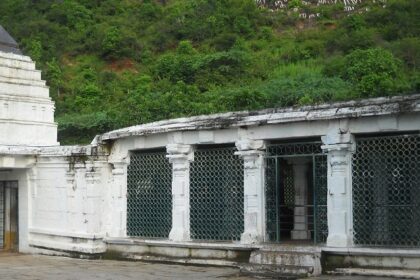 Dharmalingeswara Temple with white traditional architecture and surrounding greenery.