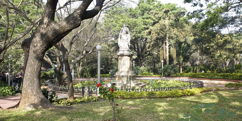 Marble statue of Queen Victoria seated on a granite pedestal in Cubbon Park