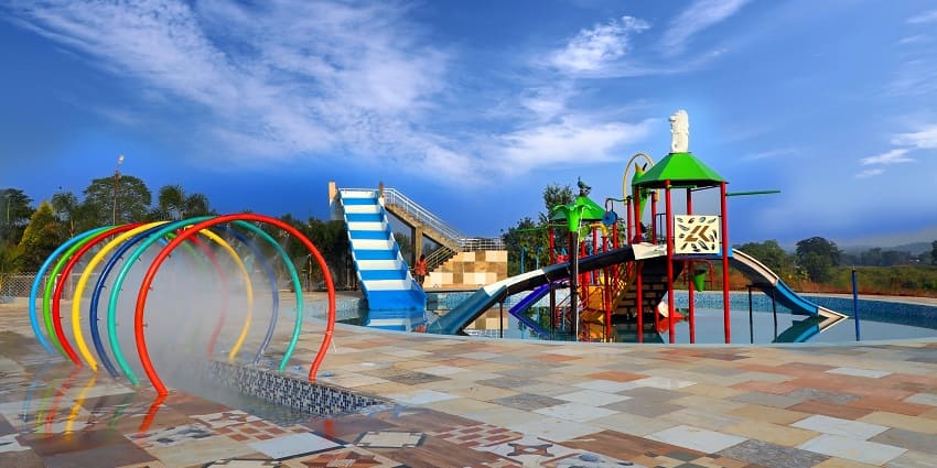 Colourful plastic water slides in a water park under sunlight at an outdoor venue.