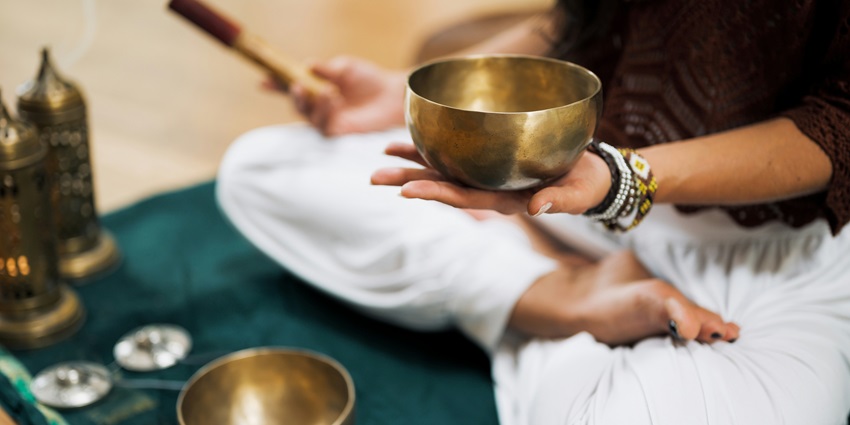A picture of an instructor using sound healing meditation technique on visitors