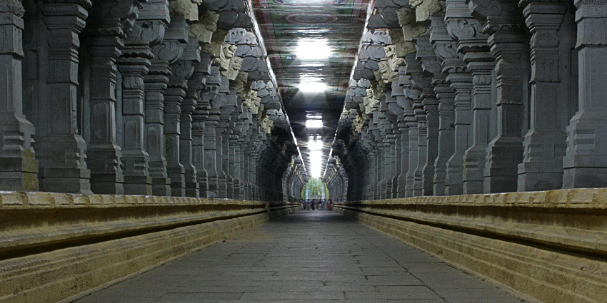 A picture of an Indian temple filled with bright colours and stunning idols and carvings.