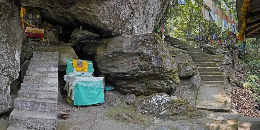 A picture of a cave in Sikkim with a small temple inside