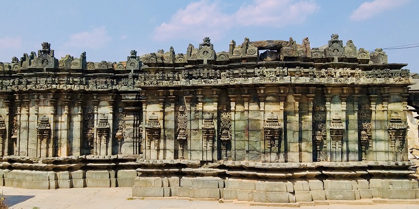 Outer view of an ancient temple which is green-coloured and has astounding architecture.
