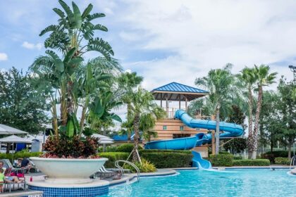 A view of the poolside with people relaxing on loungers and swimming in a waterpark.